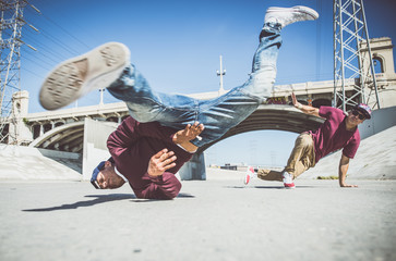 Breakdancers performing in a water duct - obrazy, fototapety, plakaty