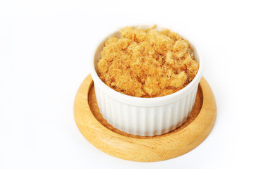 pork floss isolated in white cup on wooden saucer