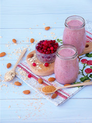 healthy smoothies from berries, oatmeal, nuts and brown sugar on a light wooden background.