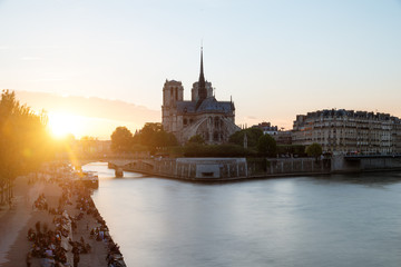 Fototapeta premium Cathedral of Notre Dame de Paris with Seine river at sunset. Par