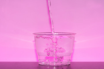 water drop in pink light.