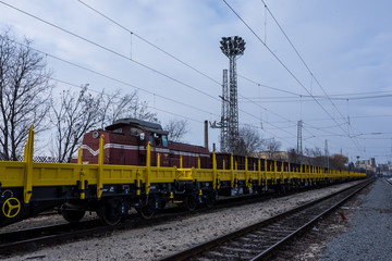 Fototapeta na wymiar Burgas, Bulgaria - January 27, 2017 - Freight cargo train - yellow black New 4-axled flat cars wagons Type:Res Model:072-2- Transvagon AD