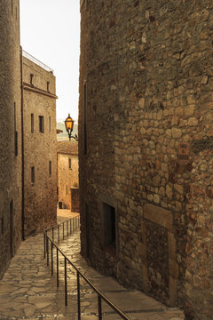 Steep and narrow winding street in gorgeous medieval hilltop walled village, Pals, Baix Emporda, Girona, Catalonia, Spain