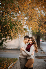 Young couple wearing on tied warm sweaters hugging in love at ci