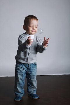 little funny boy plays with bubbles