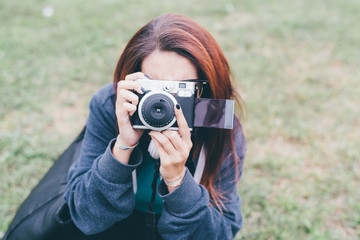 Half length of young handsome caucasian reddish straight hair woman holding an instant camera, taking a photo, looking in camera, smiling - photography, artist, creative concept