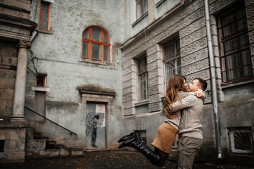 Young couple wearing on tied warm sweaters hugging in love at ol