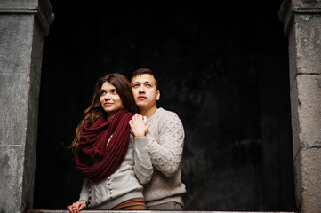 Young couple wearing on tied warm sweaters hugging in love at ol