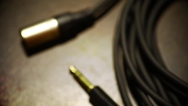 Close up footage of a a rolled up cable with jacks, with focus transition to blur.