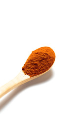 Curry powder in a wooden spoon isolated over white background