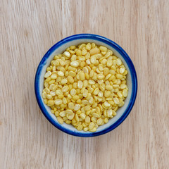  Peeled split mung bean on wood floor background.