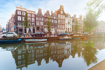 Houses and Boats on Amsterdam Canal. Morning photo of colored houses in the Dutch style with reflection in water