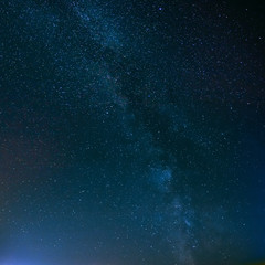 Night Starry Sky Above Field And Yellow City Lights On Backgroun