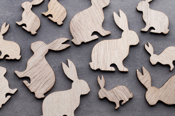Handmade wood easter rabbits on wooden background.