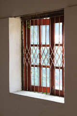 Old style Thai window on concrete wall.