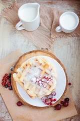 Homemade waffles with berries in a blue wooden tray