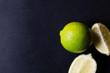Whole and sliced lime on a dark background