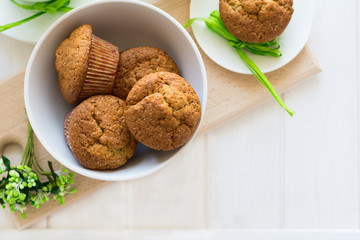 Tea time: homemade banana muffins, honey, bananas and tea settings on white wooden table. Selective focus