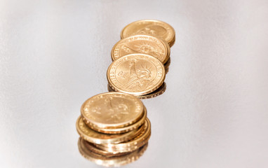 Golden coins on the reflective background.