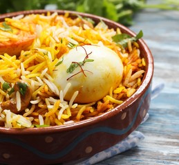 Egg Biryani served with yogurt dip on a clay pot, selective focus