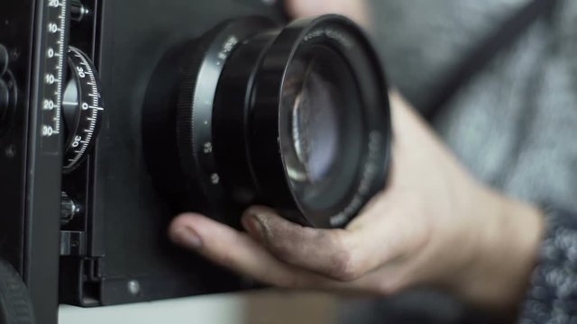 Man removes the lens with an old retro camera close-up