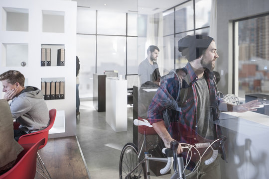 Casual man with bike in modern office