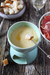 Traditional cheese fondue with baguette and glass of white wine
