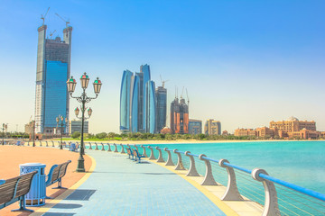 De skyline van Dhabi vanaf fietspaden van Corniche. Abu Dhabi, Verenigde Arabische Emiraten, Midden-Oosten. Moderne wolkenkrabbers en mijlpaal op de achtergrond. Zomervakantie concept.