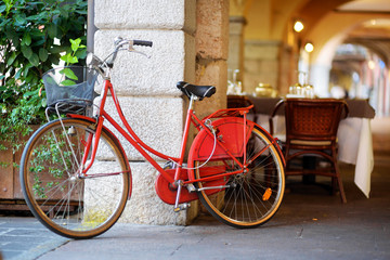 Fototapeta na wymiar Funky red bike parked on a street in Desenzano del Garda town