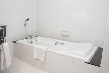 bathtub with shower in white bathroom