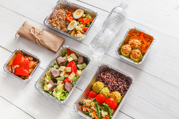 Healthy food take away in boxes, top view at wood