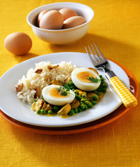 Rice with eggs, peas, mushrooms, and sauce on a plate