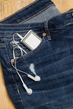Vaquero jean azul con mp3 dispositivo de m&uacute;sica en el bolsillo delantero. Vista superior y de cerca