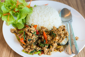 Rice topped with stir-fried pork, preserved eggs and basil on dish