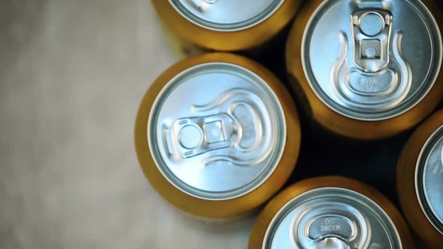 Six beer cans on wooden table, top view of alcoholic beverage