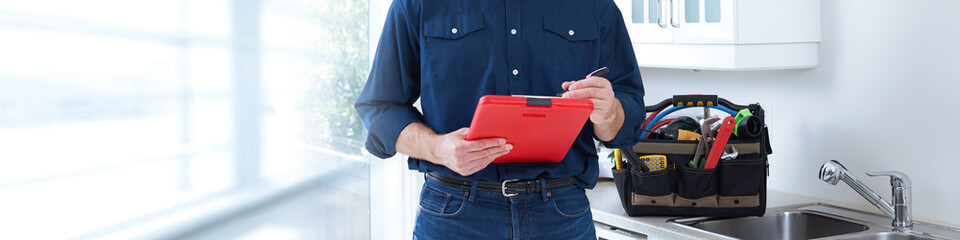 Plumber hands with clipboard.