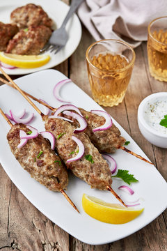 Barbecued kofta -traditional shish kebab from lamb meat with white sauce and wine.