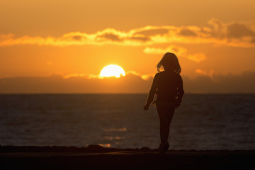 Fototapeta na wymiar Child on sunset beach during beautiful sunset