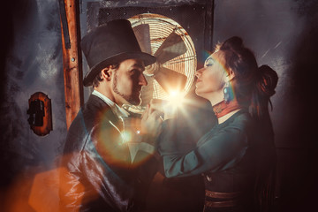 Obraz na płótnie Canvas Pretty flirting couple dressed in vintage costumes on the dark room background.