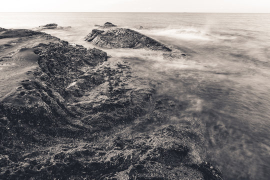 Fototapeta Waves and rocks shore long exposure