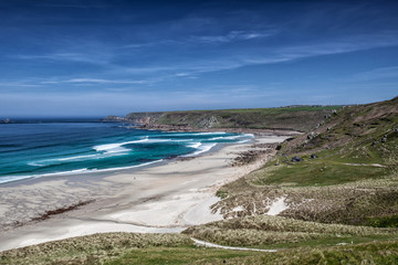 Sandy beach on summer day with blue sky in Cornwall, England