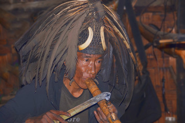 Portrait of the warrior from the tribe of Konyak headhunters smoking tobacco from the pipe which once was used to smoke opium - obrazy, fototapety, plakaty