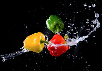 Fototapeta na wymiar Bell peppers peppers with splash isolated on black background.