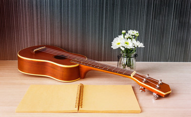 Ukulele and blank note book and flower for love music concept