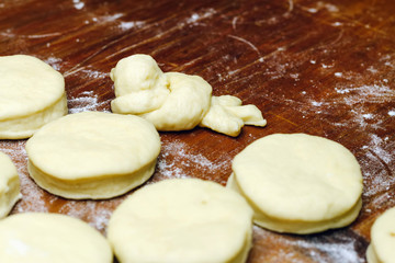 Small balls of fresh homemade dough for donuts on wooden board.