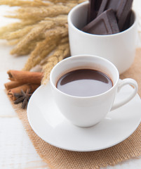 Hot Chocolate in white cups with Chocolate bar on the wooden table
