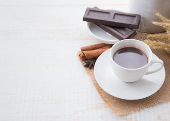Hot Chocolate in white cups with Chocolate bar on the wooden table