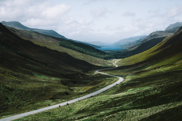 Empty road passing through grassy landscape