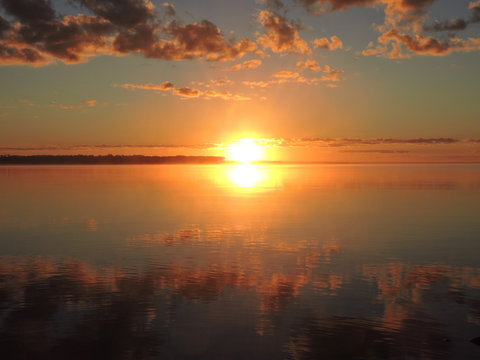 Fototapeta reflection of a sunrise over water