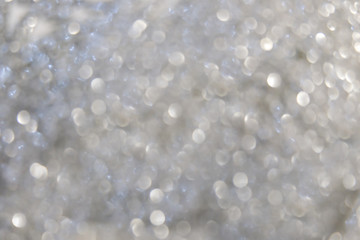 Blurred silver background with bokeh and sparkles.